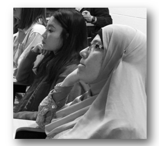 women graduate students listening to woman PhD candidate
