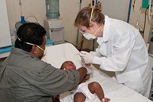 Doctor treating a baby on a gurney